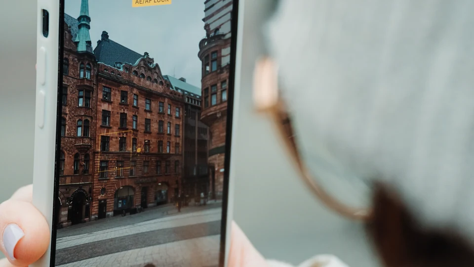 A traveler photographing historic architecture in Malmö with a smartphone.